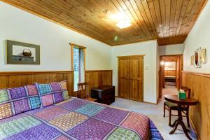 a bedroom with a large bed and a wooden ceiling at Foothill Cabin in Creston