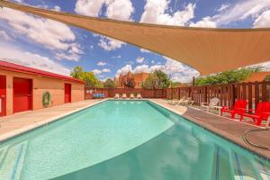 una piscina con sillas y un patio con sombrilla en Solano Vallejo 3352, en Moab