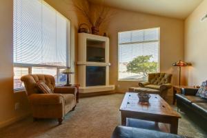 a living room with a couch and chairs and windows at Rim Village N1 in Moab
