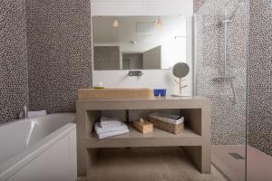 a bathroom with a sink and a tub and a mirror at Hôtel 96 in Marseille