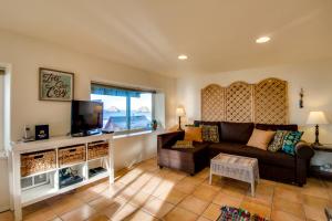 a living room with a couch and a tv at Hale Kaalawai Unit B in Oceanside