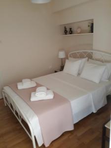 a bedroom with a white bed with two towels on it at Koukaki apartment near Acropolis in Athens