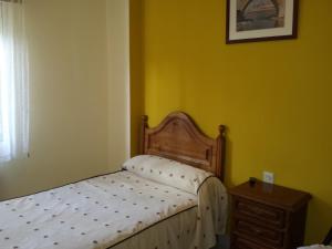 A bed or beds in a room at Hostal Atila