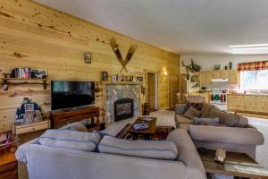 a living room with couches and a tv and a fireplace at Strawberry Log Cabin Retreat in McCall