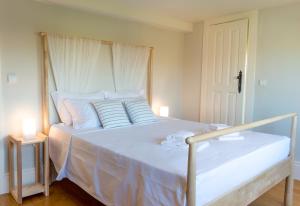
a bed room with a white bedspread and pillows at Queen's Garden Hostel in Porto
