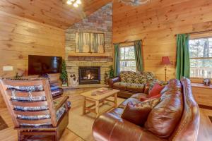 a living room with a leather couch and a fireplace at Two Bears Cabin in Wear Valley