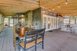 a dining room with a wooden table on a deck at Four Cubs in the Creek in Sautee Nacoochee