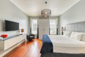 a bedroom with a bed and a flat screen tv at Savannah Lez Frederick: Premier in Savannah