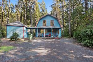a blue house in the middle of a forest at Sabala Cabin in Randolph