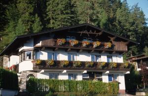 ein weißes Gebäude mit Blumenkästen auf dem Balkon in der Unterkunft Haus Salzburg in Seefeld in Tirol