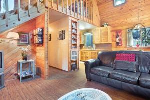 a living room with a leather couch and wooden walls at Sabala Cabin in Randolph