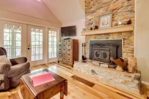 a living room with a fireplace and a stone wall at Four Cubs in the Creek in Sautee Nacoochee