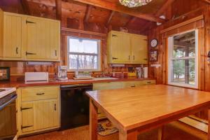 a kitchen with wooden cabinets and a wooden table at Pee Wee Acres in Thayerville