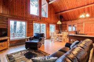 a living room with a couch and a television in a cabin at Blacktail Cabin in Somers