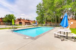 a swimming pool with chairs and umbrellas at Aspen Village #103 in McCall