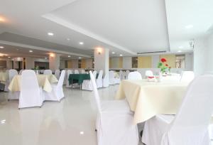 a banquet hall with white tables and white chairs at Convenient Grand Hotel in Lat Krabang