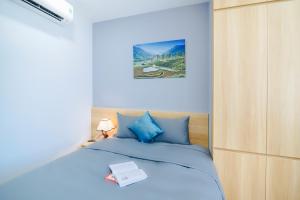 Un dormitorio con una cama azul con un libro. en Monalisa Apartment, en Da Nang 54 fotos más