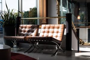 un fauteuil en cuir brun assis devant une fenêtre dans l'établissement Hotel Dei Congressi, à Rome