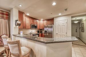 a kitchen with a counter with chairs and a refrigerator at Sunset Spectacular in Kissimmee