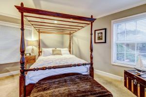 a bedroom with a four poster bed and two windows at Bayside Cottage in Bodega Bay