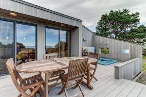 a wooden table and chairs on a wooden deck at Blue Heron in Sea Ranch