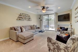 a living room with a couch and chairs and a tv at North Coast Village Retreat in Oceanside