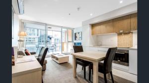cocina y sala de estar con mesa y sillas en Hi 5 star luxury Adelaide City Apartment, en Adelaida