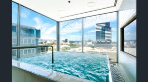 a large swimming pool in a building with windows at Hi 5 star luxury Adelaide City Apartment in Adelaide