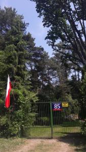 una cerca negra con una bandera roja y blanca. en Fort Janowek, en Janówek