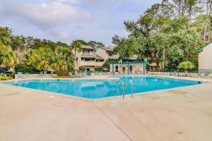 a swimming pool in front of a house with trees at Stoney Creek 272 in Hilton Head Island