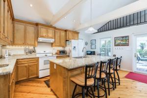 a kitchen with wooden cabinets and a large island with bar stools at Beach Oasis in Galveston