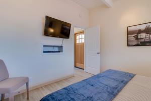 a bedroom with a bed and a tv on the wall at Surfside Suite On The Sea, Too in Gearhart