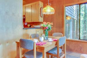 un tavolo da pranzo con sedie e un vaso di fiori di The Redwood House a Fish Rock