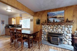 cocina y comedor con chimenea de piedra en Blue Meadow Cottage en Shaver Lake