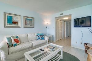 a living room with a white couch and a tv at Dunes on the Bay in Pensacola Beach