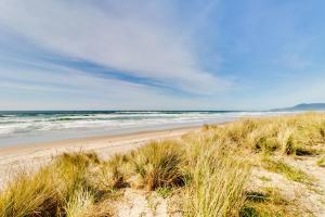 a sandy beach with the ocean in the background at A Place away from the Pace in Rockaway Beach