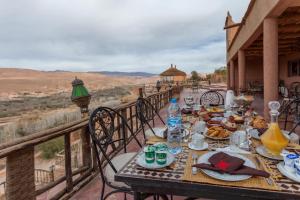 una mesa con comida y bebida en la parte superior de un balcón en Kasbah Tizzarouine, en Boumalne