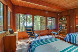 una camera da letto con due sedie e un letto e finestre di The Redwood House a Fish Rock