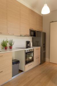 
a kitchen with a refrigerator, stove, microwave and a dishwasher at Queen's Garden Hostel in Porto
