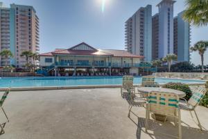 a patio with a table and chairs next to a pool at Dunes on the Bay in Pensacola Beach