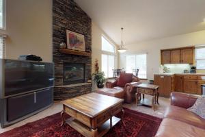 uma sala de estar com uma grande televisão e uma lareira em Quality Time em Shaver Lake