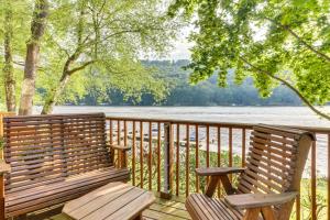 two wooden benches sitting on a deck overlooking a lake at Driftwood #6 in McHenry