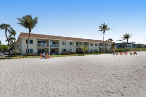a building on the beach with people on the beach at Nautilus 105 in Anna Maria