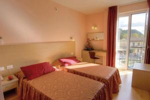 pokój hotelowy z dwoma łóżkami i oknem w obiekcie Hotel Granducato w mieście Montelupo Fiorentino