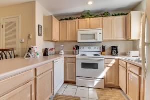 una cocina con electrodomésticos blancos y armarios de madera en Barrier Dunes Hideaway en Oak Grove