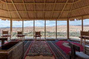 Una habitación con sillas y vista al desierto. en Kasbah Tizzarouine, en Boumalne