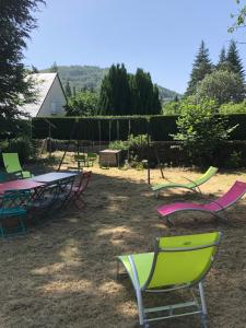eine Gruppe von Picknicktischen und Stühlen in einem Hof in der Unterkunft Les gîtes du paradis in Murol