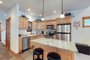una cocina con armarios de madera y electrodomésticos de acero inoxidable en Aspen Village 86 en McCall