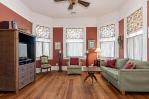 a living room with a couch and a tv at Victorian Galveston House in Galveston