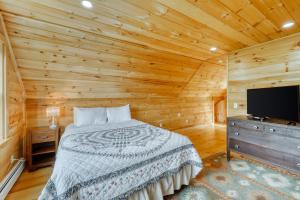 a bedroom with a bed and a flat screen tv at Andover Retreat in Ludlow